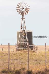 田野中的复古风车与水塔构成乡村怀旧景象