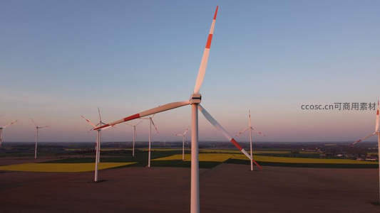 夕阳下田野中的现代风力发电机群