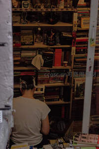 书迷在杂乱书架间寻宝，沉浸于二手书的世界