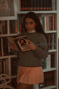 少女在书架前专注阅读经典文学著作