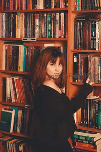 女子在木质书架前选书