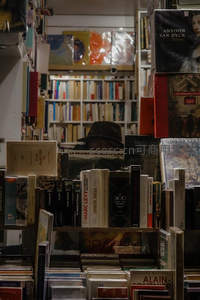 戴帽读者隐于书海，书架间若隐若现