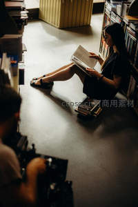 女子席地而坐专注阅读一本书