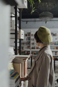戴绿帽女子在书店选书，文艺气息扑面而来