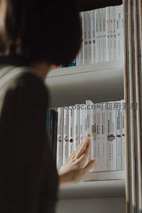 手抚书脊的温柔瞬间，沉浸在浩瀚书海中的片刻安宁