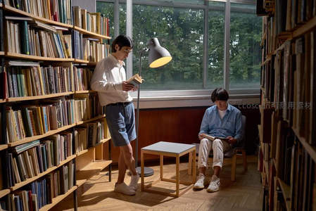 阳光洒落图书馆两人静心阅读