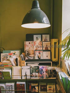 绿墙下的杂志角，复古灯罩映衬文艺时光