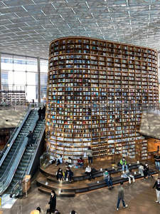 现代图书馆内巨型环形书墙与读者休憩