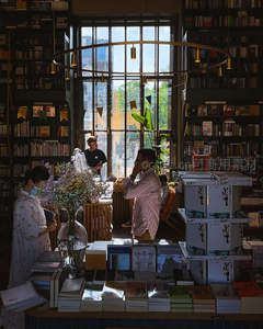 阳光洒进书店，顾客在花香中选书