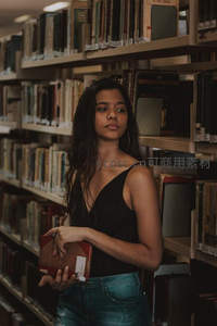 图书馆里手捧书籍的少女