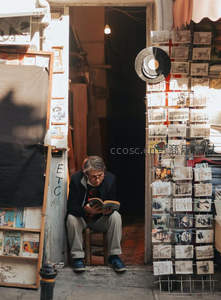 街头书摊老人静读，阳光洒落旧时光