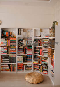 现代简约风格的客厅角落，白色书架满载书籍