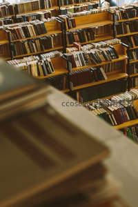 前景虚化书本，聚焦后方层层叠叠的书架