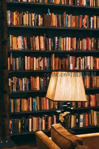 暖光台灯映照书墙，沙发一角静谧阅读