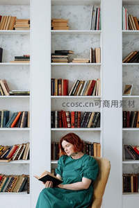 红发女子专注阅读，沉浸书页间的宁静世界