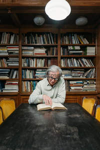 银发学者专注阅读，沉浸于浩瀚书海