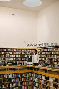 两位读者站在宏伟书墙前微笑合影