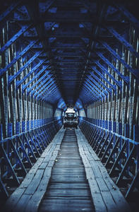 蓝色钢架桥下的木质通道