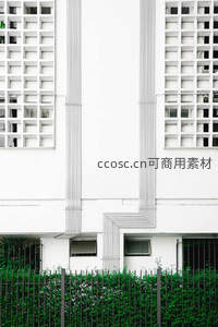 白色建筑立面与绿植围栏的几何构图