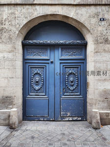 石砌拱门下斑驳的复古蓝门