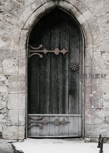 哥特式石拱门内的沧桑木门