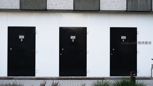 三扇黑色门并排在白色墙面上