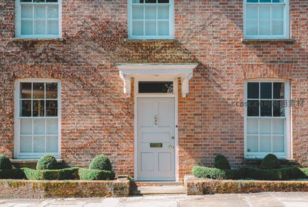 红砖别墅前典雅的白色大门与修剪整齐的绿植