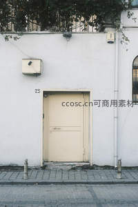 白色外墙上的米色门与数字25