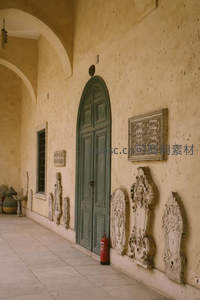 米黄色走廊中绿色拱门与石雕装饰