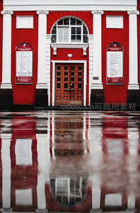 雨后红墙建筑倒影在水洼中