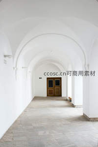 白色拱廊尽头的木门静谧走廊