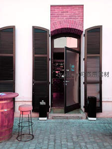 拱形砖门与深色百叶窗的街角咖啡馆入口