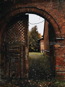 红砖拱门后的秋日庭院