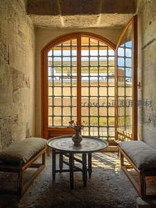 石墙拱窗小憩处，花瓶静置享日光