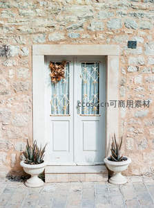 石墙古门两侧绿植点缀静谧庭院