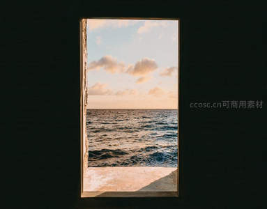 窗框框住海景，夕阳波光粼粼如画