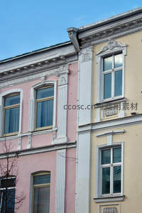 粉黄双色建筑立面，古典雕花窗框细节