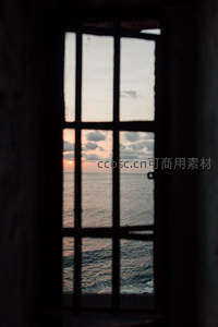 铁窗框住的海天落日，云霞染金波光粼粼