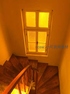 暖黄灯光下的木质旋转楼梯，复古而温馨