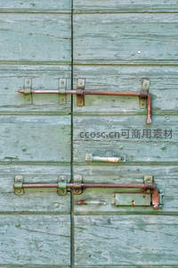 绿色木门上的双层铁质门闩特写