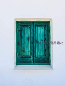 纯白墙面中一抹复古绿窗的宁静