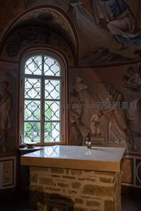 教堂彩绘壁画环绕，拱形花窗透进柔和日光