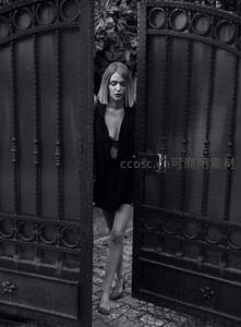 黑白光影中走出铁门的女子