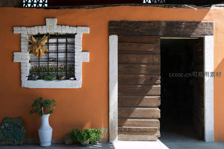 橙墙木门与窗台绿植的静谧角落