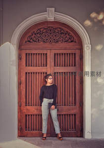 复古木门旁的时尚女性剪影