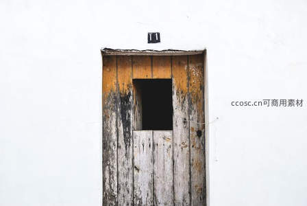 斑驳木门与纯白墙壁的对比