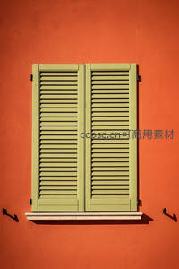 橙色墙面上浅绿色百叶窗的几何美感