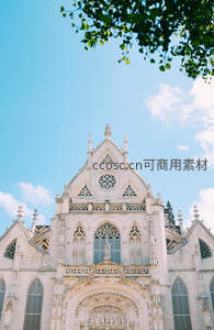 哥特式教堂尖顶在蓝天绿叶下庄严矗立