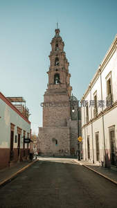 街道尽头矗立的古老钟楼映衬晴空