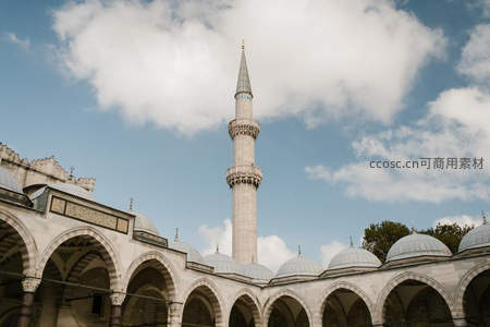 蓝天白云下的清真寺尖塔与拱廊